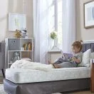Toddler sitting on toddler bed mattress Thumbnail