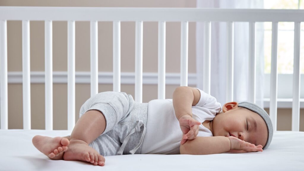 sleeping baby on crib mattress